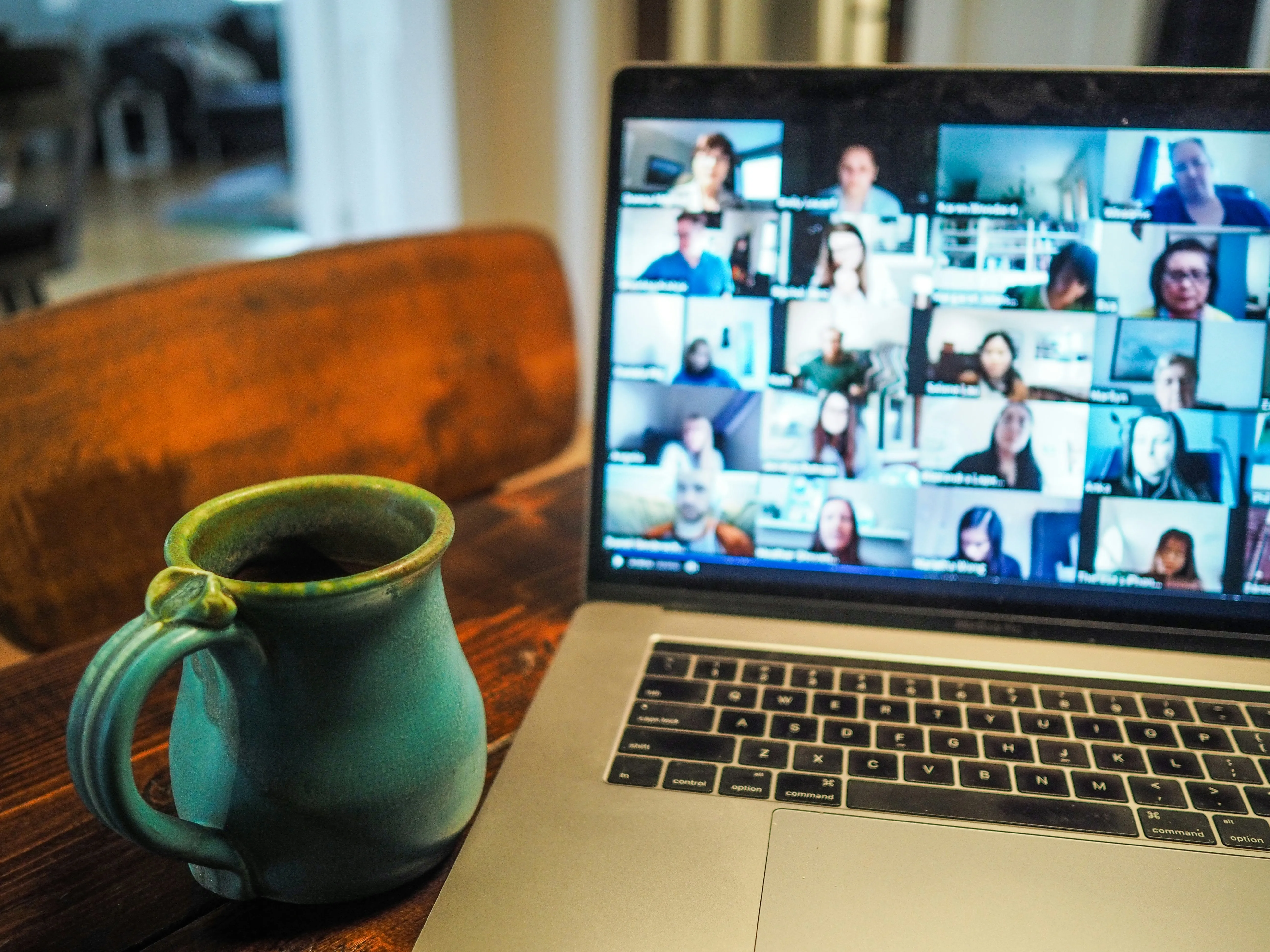 Laptop showing a video call near a coffee pot